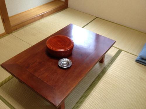 a wooden table topped with a coffee cup at Iroha Ryokan in Aomori