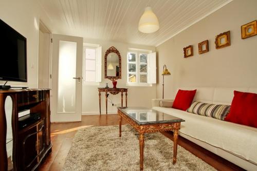 a living room with a couch and a table and a tv at Duplex Lisbon Castle Sao Jorge in Lisbon