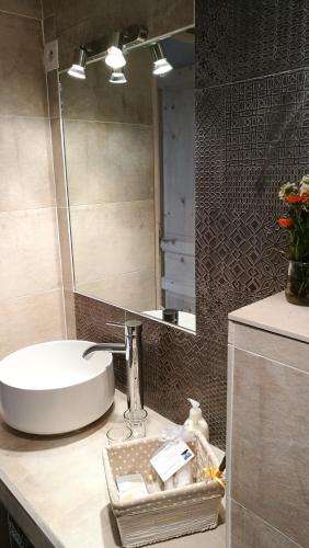 une salle de bain avec un lavabo et un miroir dans l'établissement La petite maison, à Sisteron