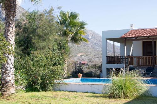 a villa with a swimming pool with a mountain in the background at Felia Villa in Stavros