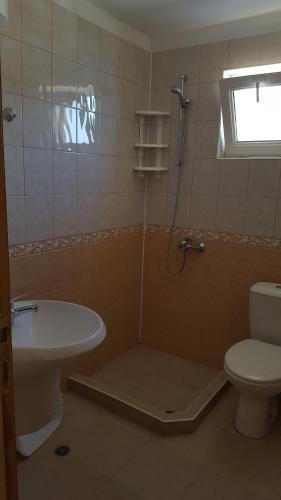 y baño con ducha, aseo y lavamanos. en Villa Krisia Apartments, en Sozopol