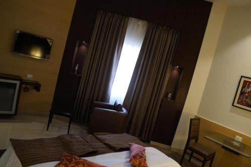 a bedroom with a bed and a window with curtains at Nakshatra Residency in Ambernath