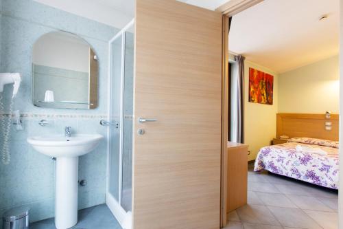 łazienka z umywalką i sypialnia w obiekcie Albergo Verdi w mieście Novi Ligure