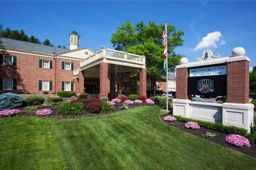 un edificio con una bandera y flores en un patio en Ohio University Inn and Conference Center en Athens