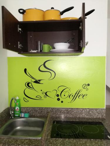 a kitchen sink with the words coffee written on it at Francisco Habitaciones in Manta