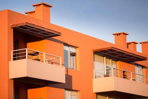un edificio naranja con 2 balcones en Lomas del Real Aparthotel, en Colonia del Sacramento