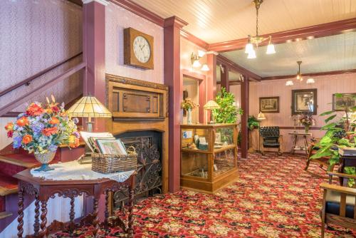a lobby with a fireplace and a clock on the wall at Julian Gold Rush Hotel in Julian