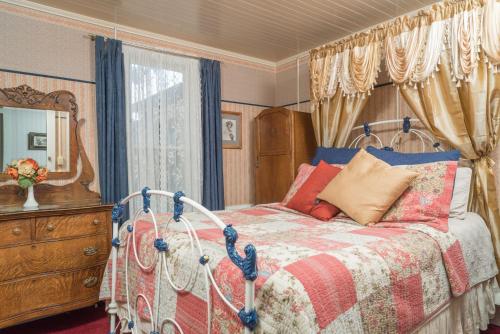 a bedroom with a bed and a dresser and a mirror at Julian Gold Rush Hotel in Julian