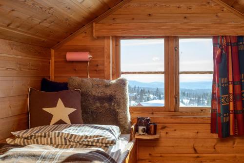 a room with a bed and a window in a cabin at Nordseter Hytter in Nordseter