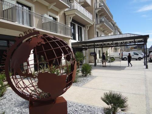 a large bronze globe sitting outside of a building at Hôtel Le Nouveau Monde in Saint Malo
