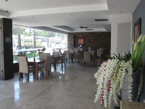 a dining room with tables and chairs and a brick wall at Grann Hotel in Ciudad Valles