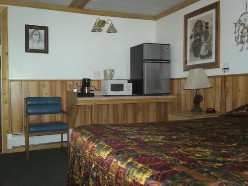 a hotel room with a bed and a microwave at Antler Motel in Greybull
