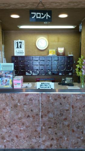 a counter in a store with a clock on the wall at Business Hotel Motonakano in Tomakomai