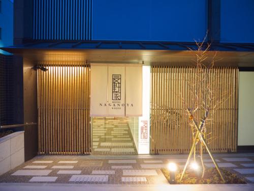 a front door of a building with a tree in front at Naganoya in Kyoto