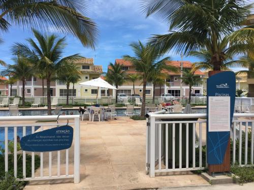 a sign in front of a resort with palm trees at Loft Reserva do Sahy - Mangaratiba in Mangaratiba