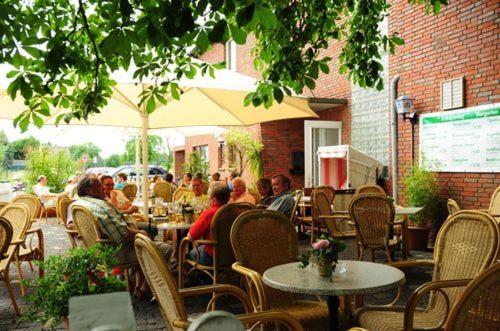 a group of people sitting at an outdoor restaurant at Hotel Schäferhof in Bückeburg