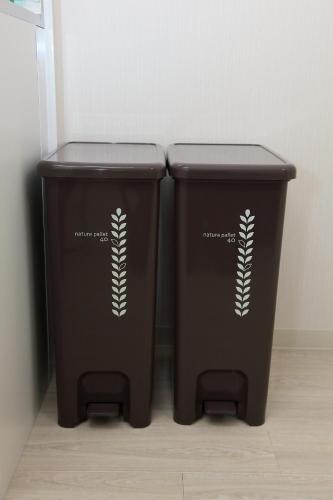 two black trash cans sitting next to each other at Apartment Heights HANA in Sakai