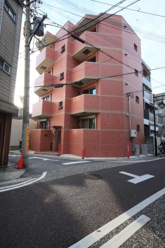 a red building on the side of a street at Apartment Heights HANA in Sakai