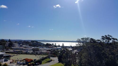a plane flying over a city with a body of water at Casablanca Penthouse Loft - Landmark 518 in Nelson Bay