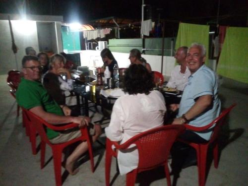 a group of people sitting at a table in a restaurant at Nathans Holiday Home in Cochin