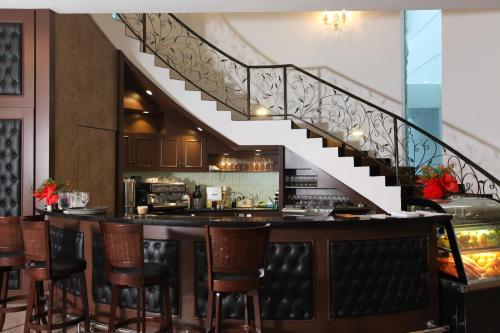 a bar with chairs and a staircase in a restaurant at Casa Bianca in Kluang