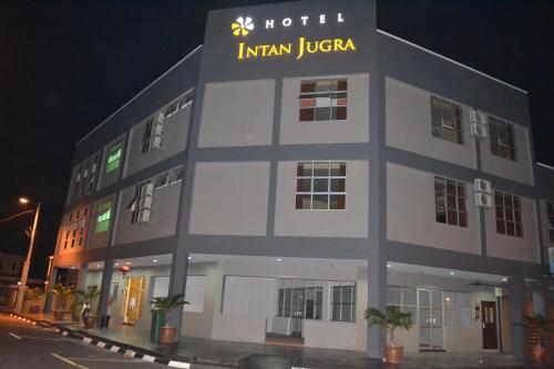 a white hotel with a sign on the side of it at Hotel Intan Jugra in Banting