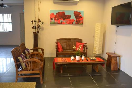 sala de estar con mesa, sillas y TV en Hotel Intan Jugra, en Banting