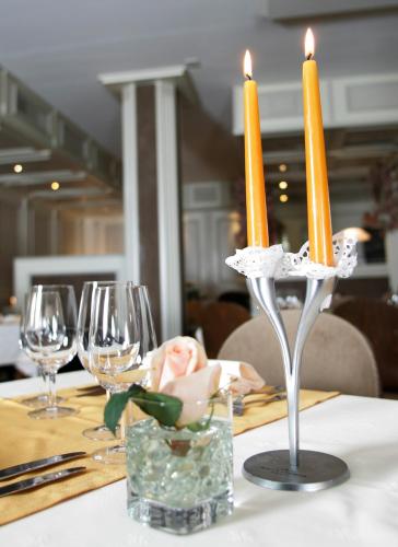 a table with two candles on a table with wine glasses at Hôtel Le National in Delémont