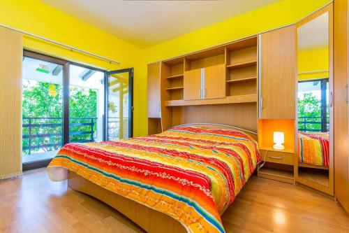 a bedroom with a bed with a colorful blanket at Apartment ELIANA in Banjole