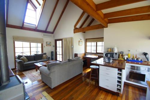 a kitchen and living room with a couch and a table at Manzanilla Ridge in Rothbury