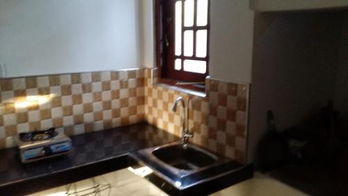 una cocina con fregadero y ventana en Dumi House, en Weligama