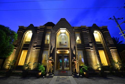 two people in gold costumes standing in front of a house at Northern Breeze Hotel in Bagan