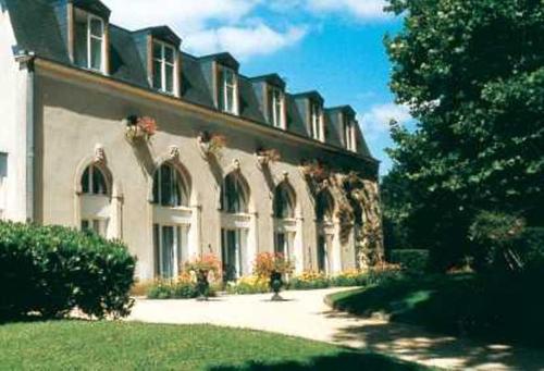 een groot gebouw met een grasveld ervoor bij Château de Bazeilles in Bazeilles