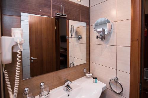 uma casa de banho com um lavatório e um espelho em HELIOPARK Residence em Penza