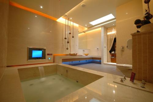 a large bathroom with a tub with a tv in it at Norway Forest SPA Motel in Xindian