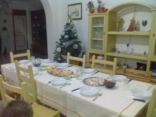 einen Tisch mit Essen und einen Weihnachtsbaum in einem Zimmer in der Unterkunft B&B Pacheco in Paceco