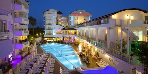 a view of a hotel with a swimming pool at night at Merve Sun Hotel & SPA in Side