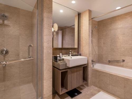 a bathroom with a sink and a shower at Somerset Millennium Makati in Manila