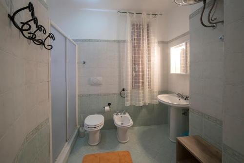 Baño blanco con aseo y lavamanos en Home Sweet Home, en Trapani