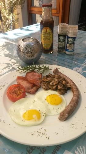 a plate of eggs and sausage on a table at 17 on Bird Guest House in Beaufort West