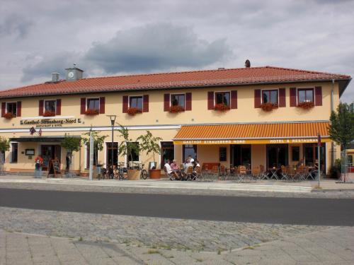 a building on the side of a street with people sitting outside at Gasthof Strausberg Nord in Strausberg