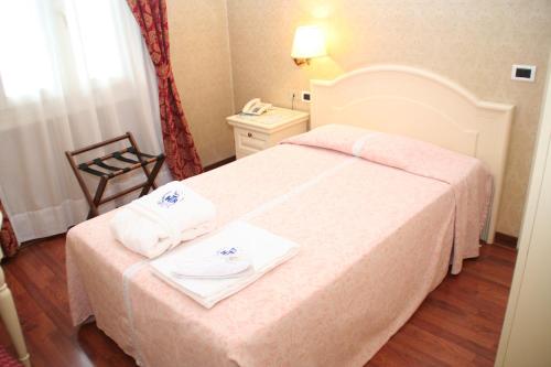a hotel room with a bed with towels on it at Hotel Terme Roma in Abano Terme
