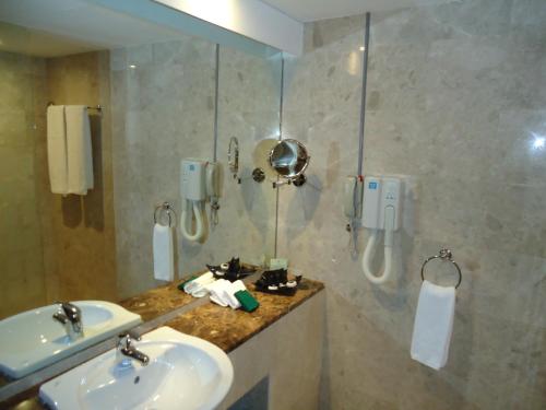 a bathroom with two sinks and a shower at Al Jazira Club Hotel in Abu Dhabi