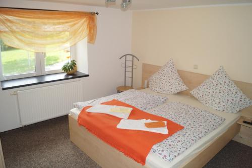 um quarto com uma cama com duas toalhas em Landsauna - Pension em Zittau