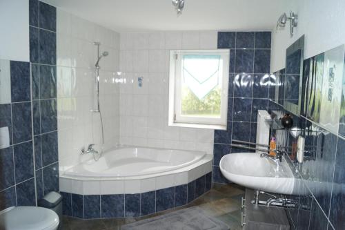 uma casa de banho com uma banheira, um WC e um lavatório. em Landsauna - Pension em Zittau