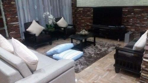 een woonkamer met een witte bank en een piano bij Affordable Baguio APT in Baguio