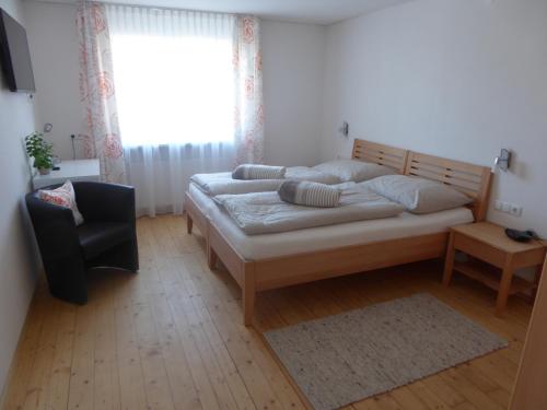 a bedroom with a bed and a chair and a window at Schottar FeWo ST 09 in Dornbirn