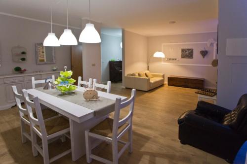a kitchen and living room with a white table and chairs at La Maison di Brigitte e Simone in Bentivoglio