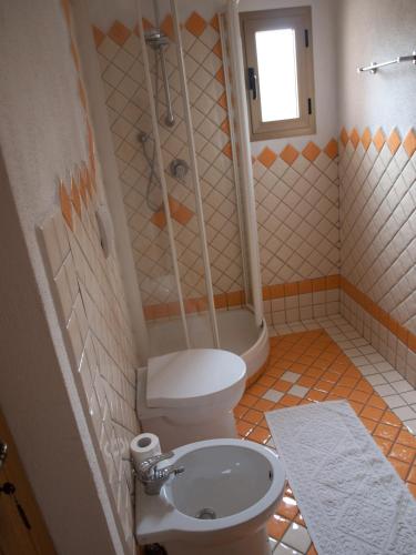 a bathroom with a toilet and a shower and a sink at Stella di Mare in La Maddalena