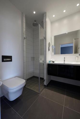 a bathroom with a shower and a toilet and a sink at Best Western Plus Hotel Fredericia in Fredericia